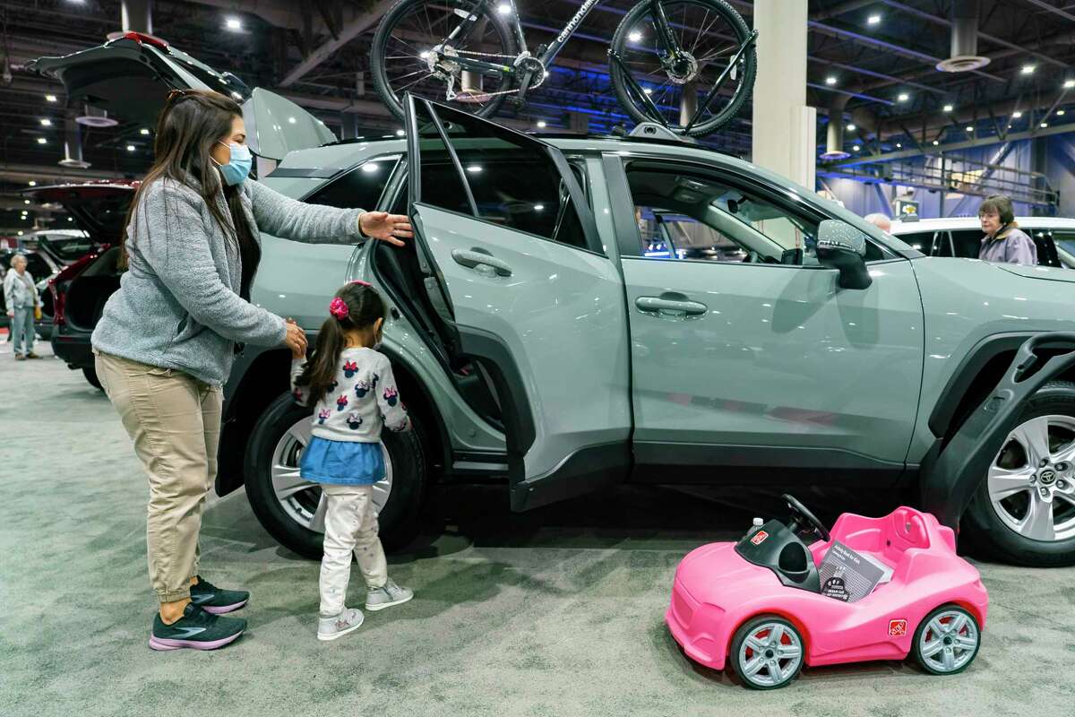 Romi Camarillo shows her daughter, Sophie, 3, a RAV4 at the 2022 combined Houston Boat Show and Houston Auto Show, Thursday, Jan. 27, 2022, at NRG Center. Romi and her husband, Juan, have just started the process of buying a new car, and they wanted to come look in an environment where they would not be hounded by salespeople, said Juan Camarillo. Steep prices and lack of inventory are not keeping the family out of the car market. “If you need it, you need it. If it’s time to replace it, it’s time,” said Camarillo.