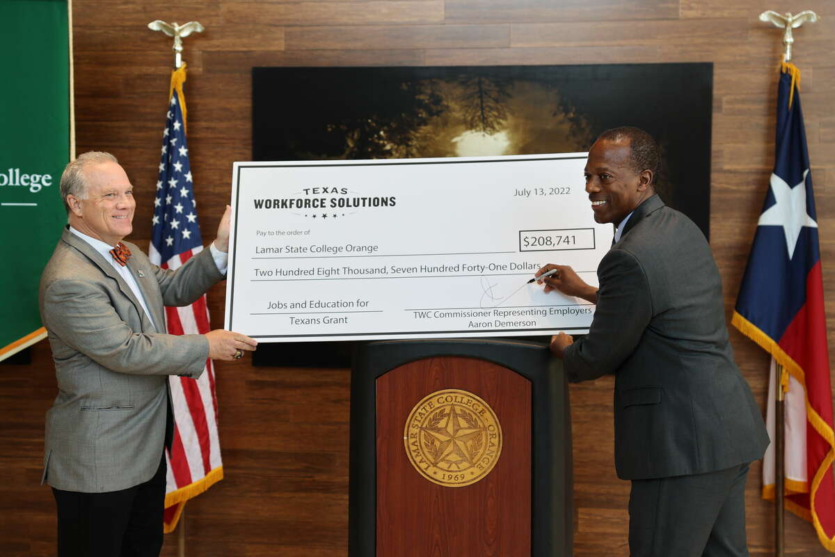 Texas Workforce Commissioner Aaron Demerson, right, signs the more than $208,000 check awarding Lamar State College Orange a Jobs and Education for Texans grant while LSCO President Tom Johnson, left, accepts the funding. Photo taken July 13, 2022.