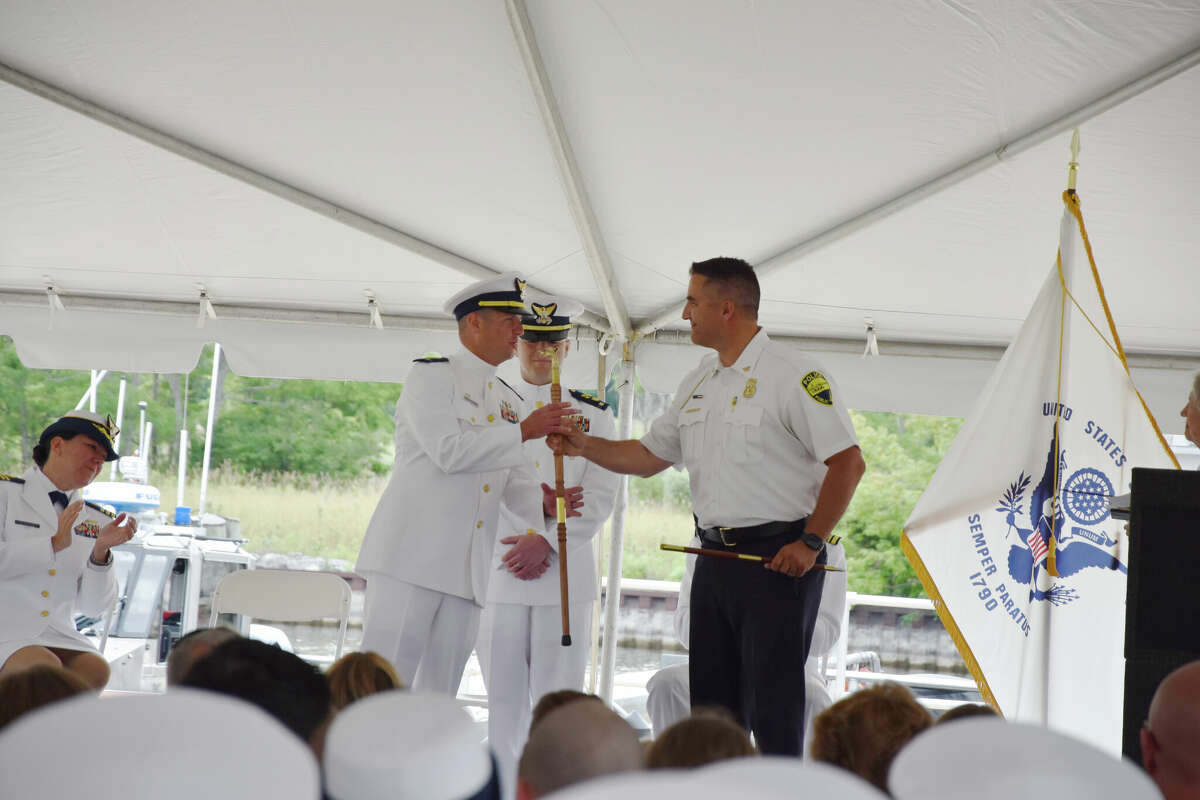 Manistee City Police Chief Josh Glass gifts a hand-carved wooden cane from the city of Manistee to retiring Chief Warrant Officer Jesse Bruce on Friday at a special ceremony. 