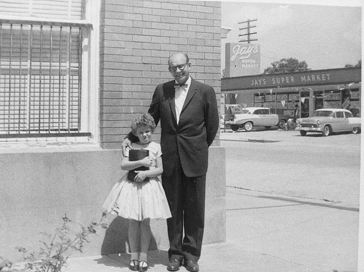 A young Donna Swanson and her father on the corner of the old bank building on FM 2100 near the railroad track. They were dressed for Easter church celebration.