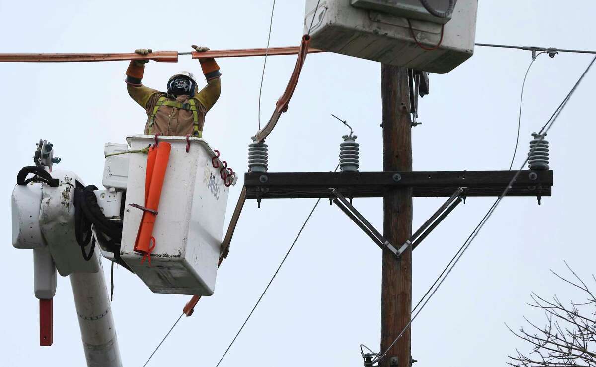 A lineman contracted by CPS Energy work on a downed line in Castle Hills as a strong cold front blows into town causing icy conditions on Thursday, Feb. 3, 2022. Several crews were in the area working to restore power to area residents.