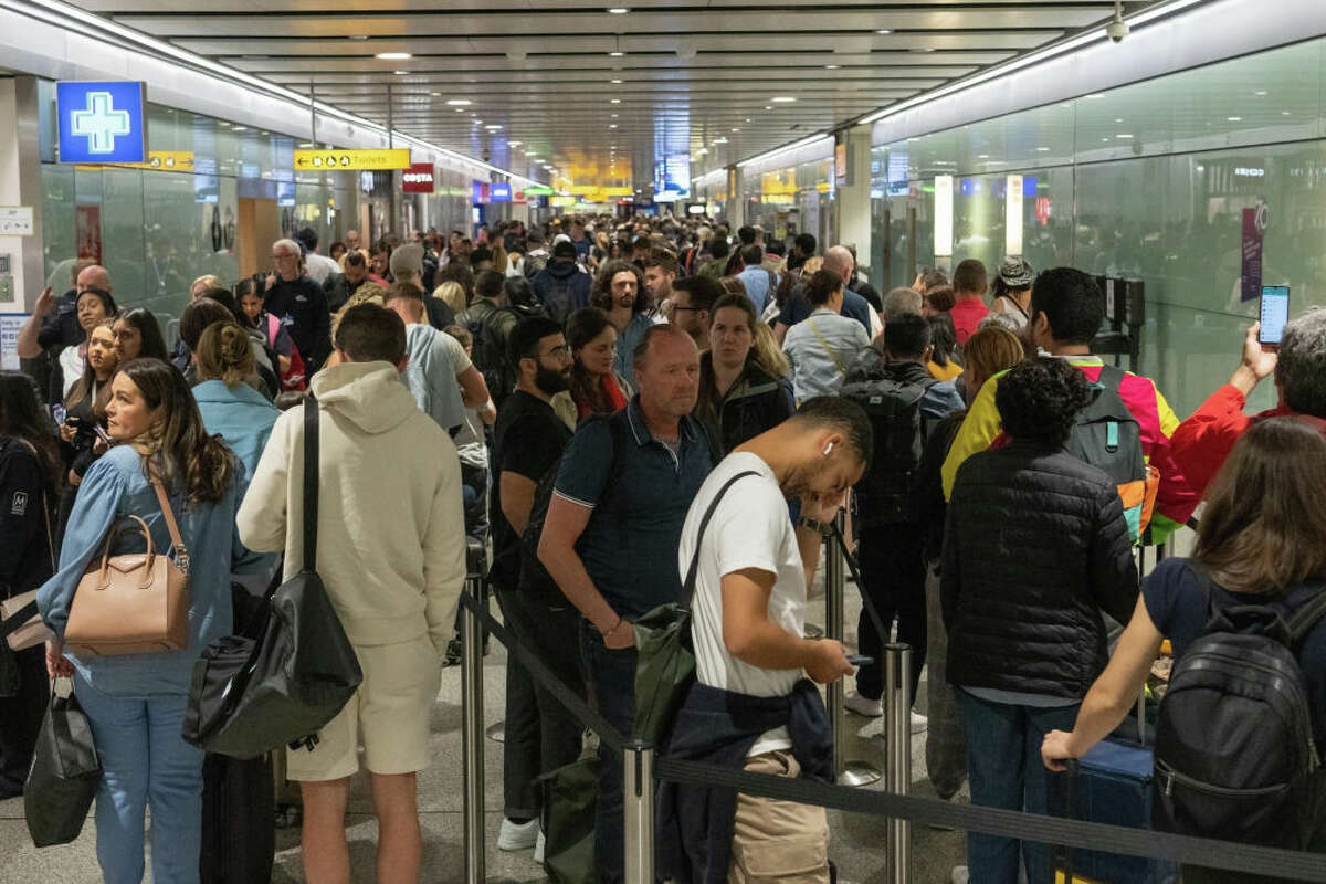 Travelers wait in a long queue to pass through the security check at Heathrow on June 1, 2022, in London.