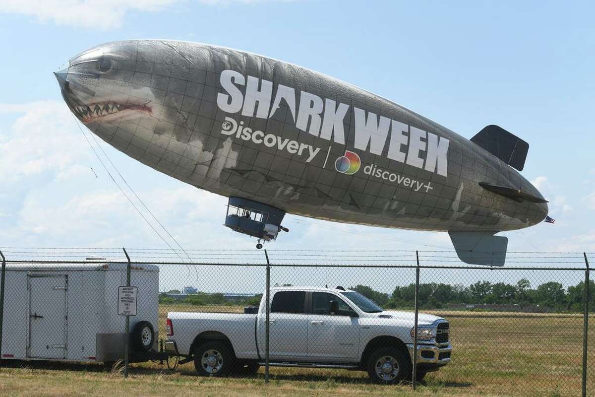 A blimp promoting Discovery Channel’s Shark Week lifts off from Sikorsky Memorial Airport, in Stratford, Conn. July 15, 2022. Owned and operated by AirSign Airship Group, the blimp stopped for about twenty minutes in Stratford Friday afternoon to refuel on a day-long trip from Cape Cod to New Jersey. Nicknamed “East Shark”, it is one of two of AirSign’s blimps flying over beaches on both the east and west coasts this summer to promote Shark Week, which debuts its 2022 season at the end of July.