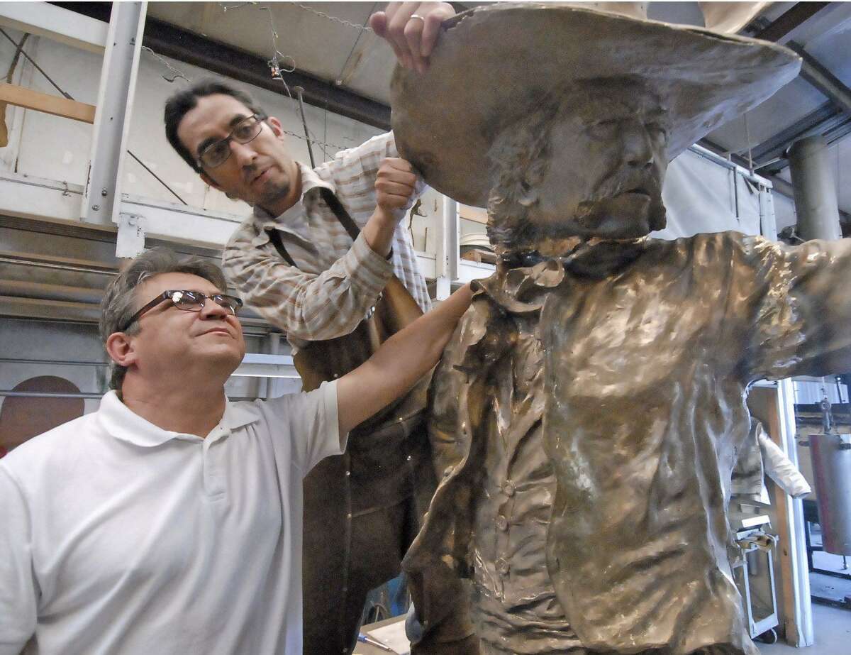 Sculptor Craig Campobella and Manuel Flores work on “The Texian” statue in March 2011.