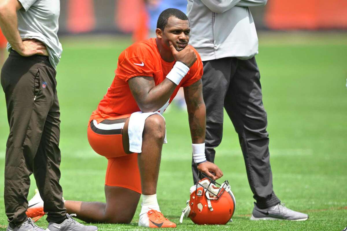 FILE - Cleveland Browns quarterback Deshaun Watson kneels on the field during an NFL football practice at the team's training facility on June 8, 2022, in Berea, Ohio. Thirty women who had accused the Houston Texans of turning a blind eye to allegations that Watson was sexually assaulting and harassing women during massage sessions have settled their legal claims against the team, their attorney said Friday, July 15, 2022. Watson, who has since been traded to the Cleveland Browns, has denied any wrongdoing and vowed to clear his name. (AP Photo/David Richard, File)