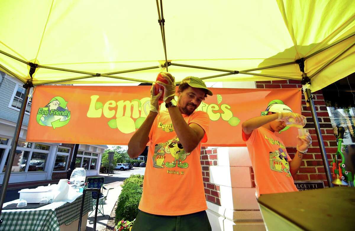 Nate Bryant, who operates Lemon Nate's, prepares a strawberry cherry drink during the Darien Chamber of Commerce’s Darien Sidewalk Sales event for businesses up and down Post Road in Darien, Conn., on Friday July 15, 2022. The sidewalk sales will also run from July 16, 10 a.m. to 5 p.m.