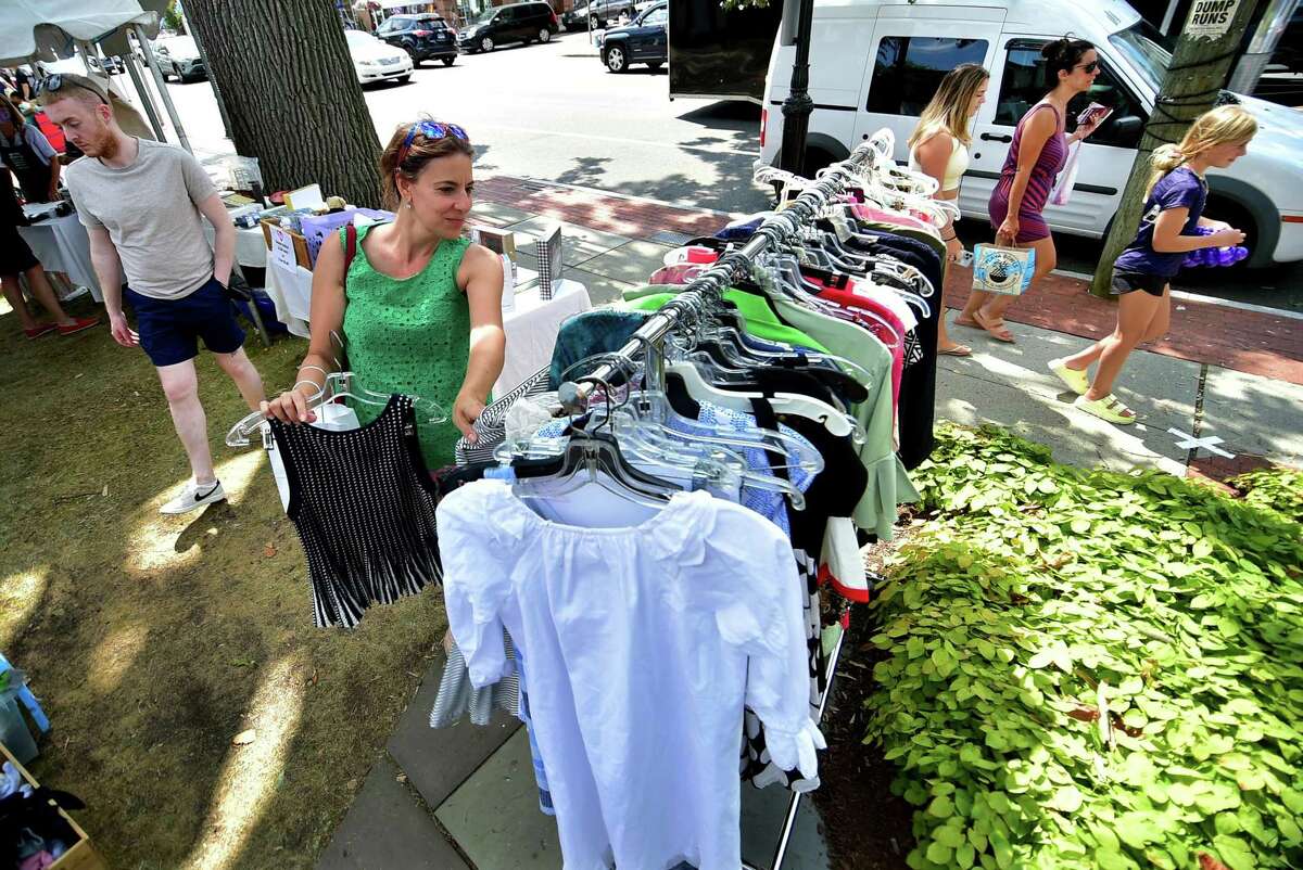 Tina Bartels looks for a deal while browsing at The Darien Community Association Thrift Shop during the Darien Chamber of Commerce’s Darien Sidewalk Sales event for businesses up and down Post Road in Darien, Conn., on Friday July 15, 2022. The sidewalk sales will also run from July 16, 10 a.m. to 5 p.m.