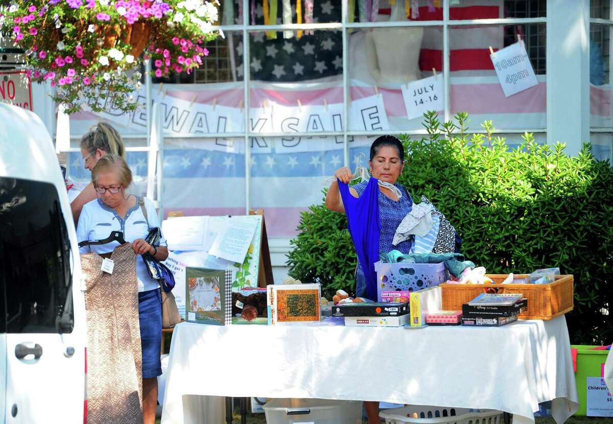 Shoppers look for deals while browsing at The Darien Community Association Thrift Shop during the Darien Chamber of Commerce’s Darien Sidewalk Sales event for businesses up and down Post Road in Darien, Conn., on Friday July 15, 2022. The sidewalk sales will also run from July 16, 10 a.m. to 5 p.m.