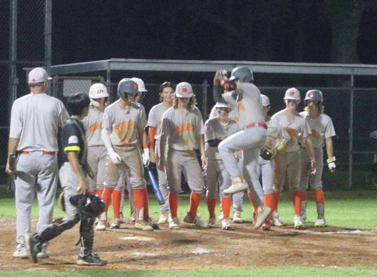 The NASA Orange 14-year-old all-stars greet Alex Erdesun at home plater after he connected for a home run that sailed over the 285-foot sign in the fourth inning Friday night.