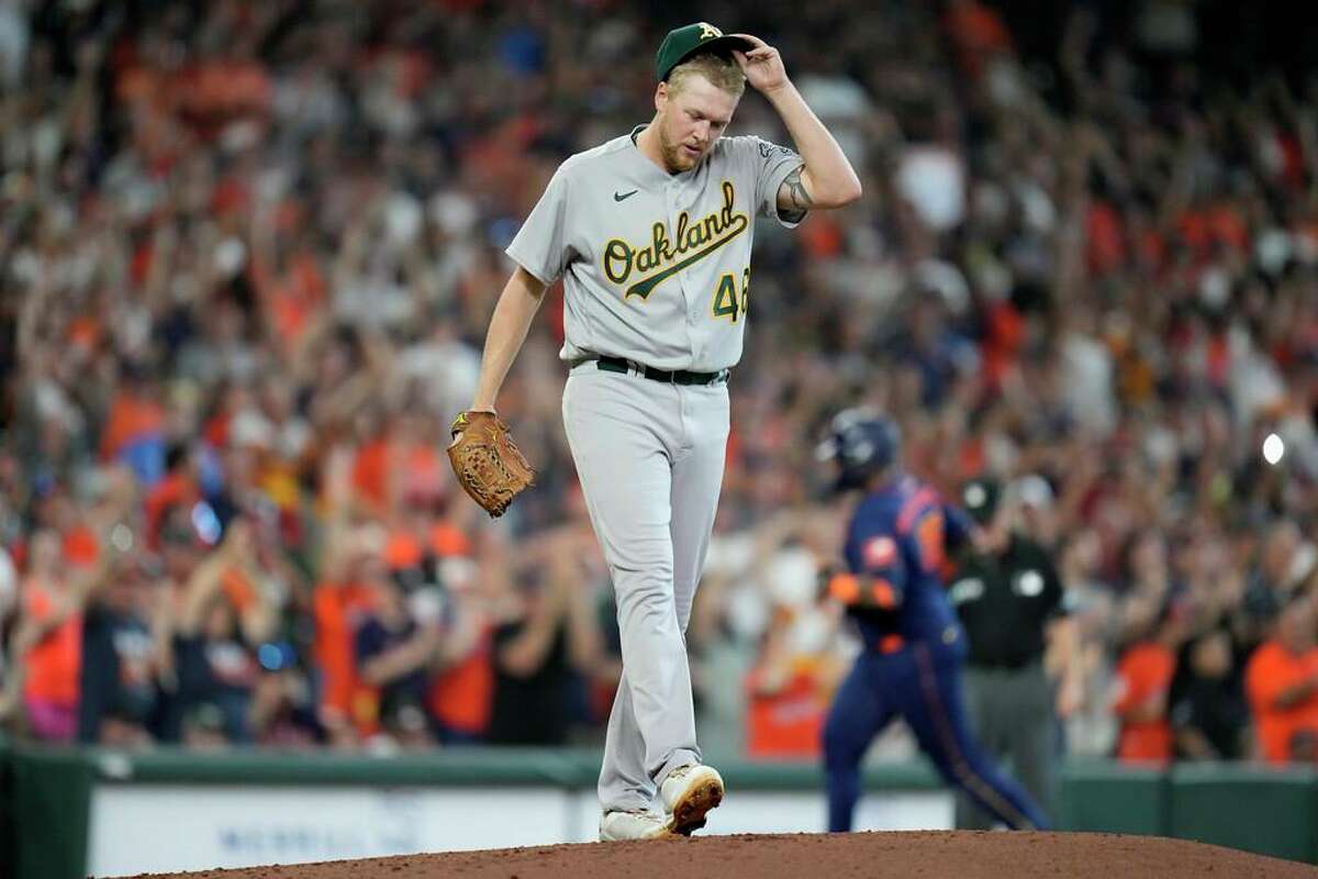 Oakland Athletics starting pitcher Jared Koenig, center, walks back to the mound as Houston Astros' Martin Maldonado, back right, rounds the bases after hitting a grand slam during the second inning of a baseball game, Saturday, July 16, 2022, in Houston. (AP Photo/Eric Christian Smith)