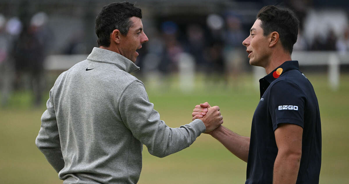 Norway's Viktor Hovland, right, and Northern Ireland's Rory McIlroy, left, shake hands on the 18th green after their third rounds on Day Three of The 150th British Open Golf Championship on The Old Course at St Andrews in Scotland on Saturday, July 16, 2022. (Paul Ellis/AFP/Getty Images/TNS)