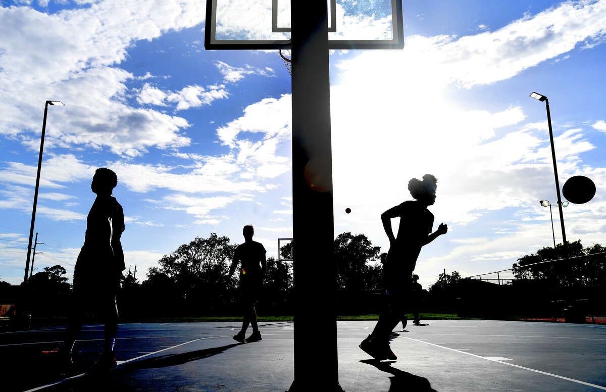 Friends get in a game of basketball on the new court at Rogers Park. The facility is one of two Beaumont city parks to get improvements. Port Arthur has two new park renovation projects in the works Photo made Friday, July 15, 2022. Kim Brent/The Enterprise