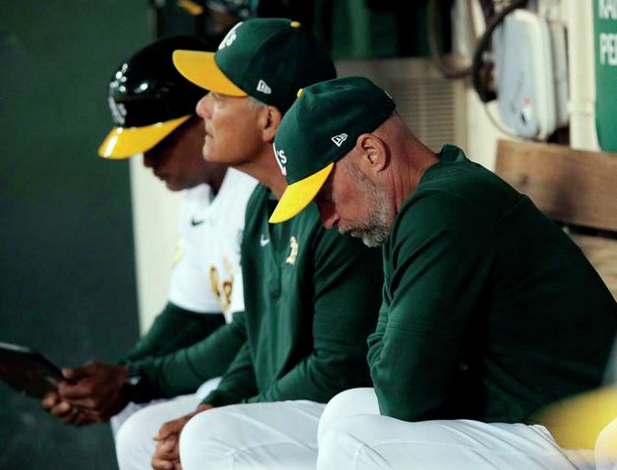 Manager Mark Kotsay (right) and the A’s are on pace for the franchise’s second 100-loss season in Oakland.