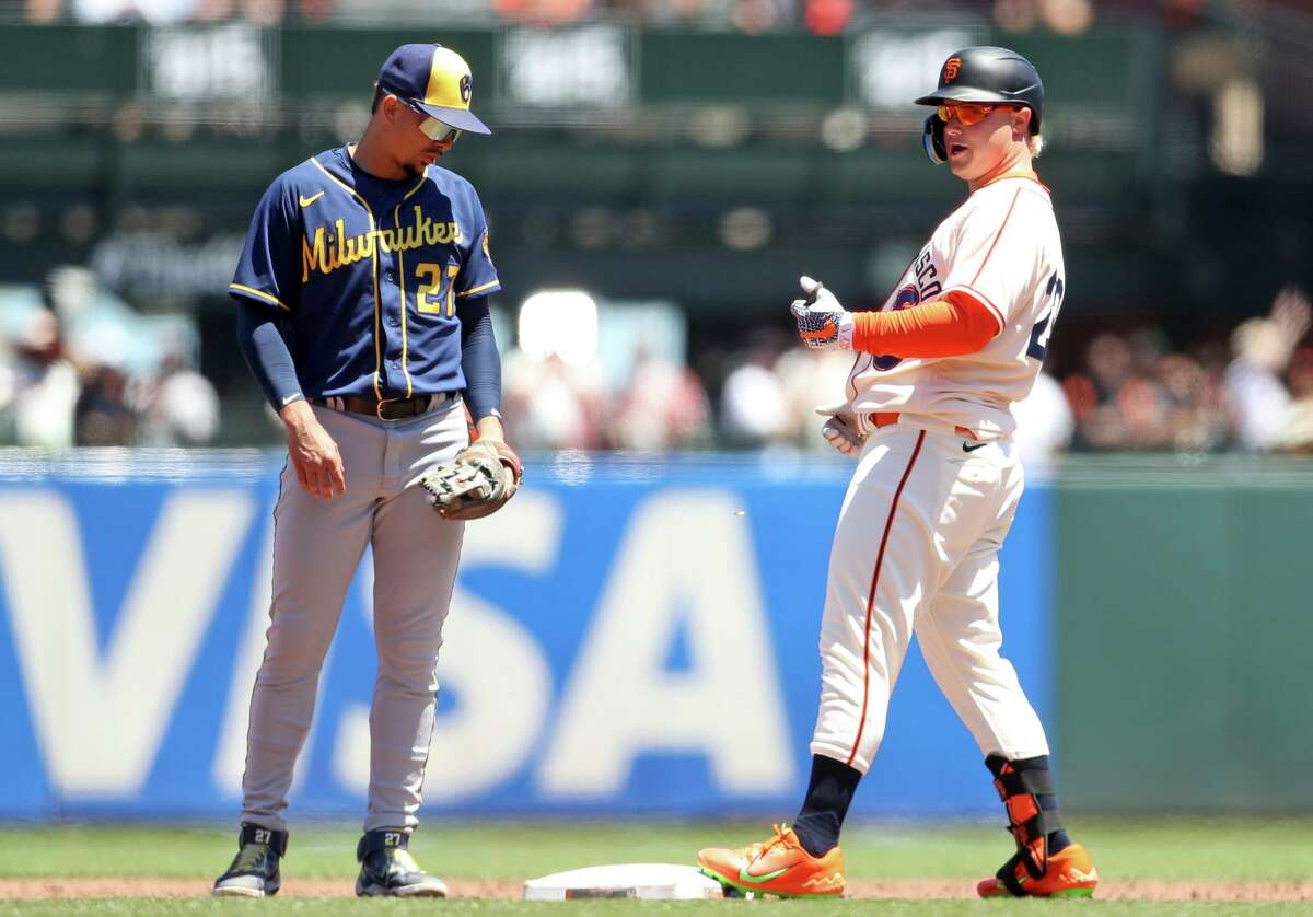 San Francisco Giants’ Joc Pederson reacts to his RBI double in 3rd inning as Milwaukee Brewers’ Willy Adames watches during MLB game at Oracle Park in San Francisco, Calif., on Sunday, July 17, 2022.