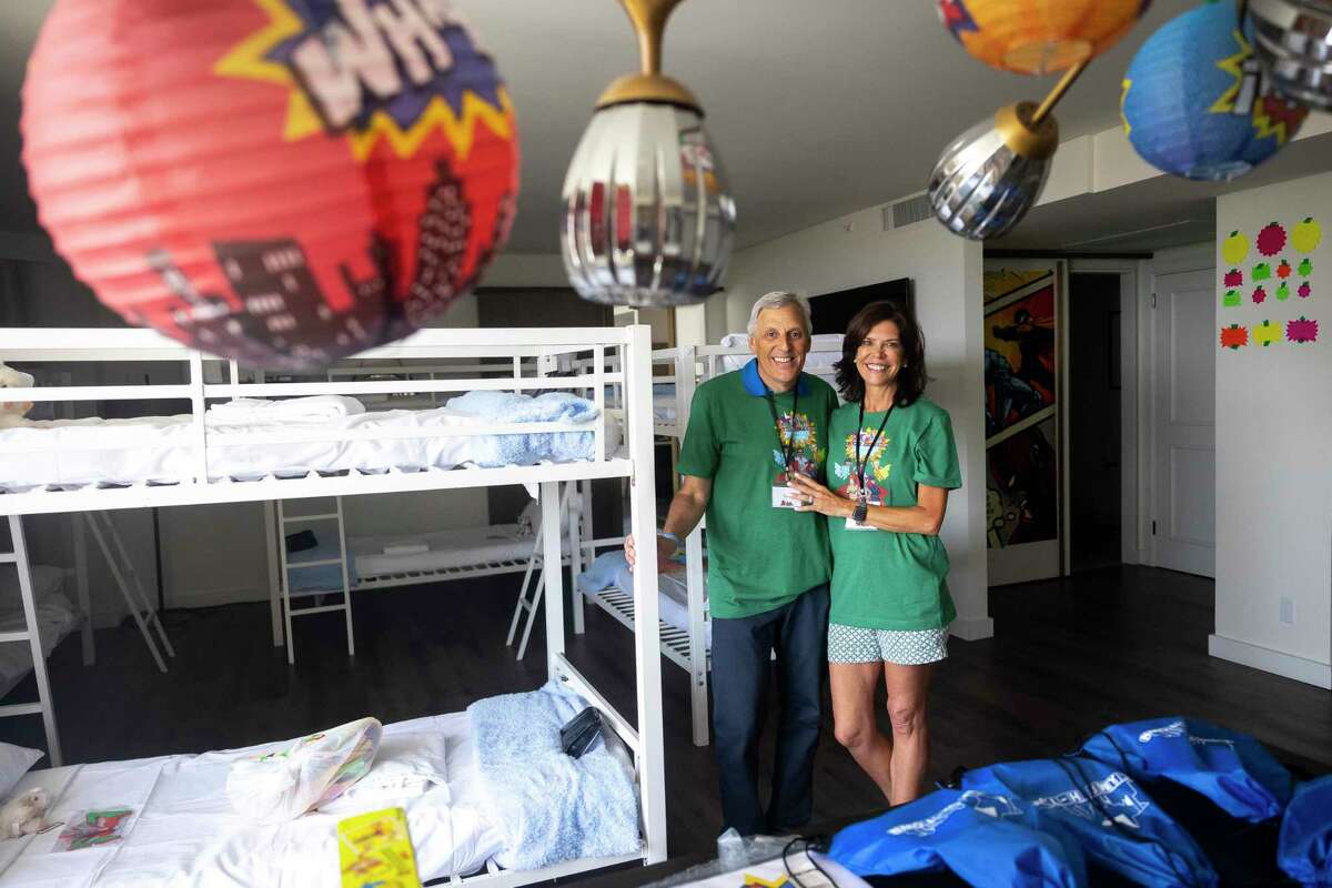Tom and Robin Segesta pose for a portrait in one of the decorated bunk rooms during the first day of in-person camp at the Four Seasons Hotel in downtown Houston on Sunday, July 17, 2022.