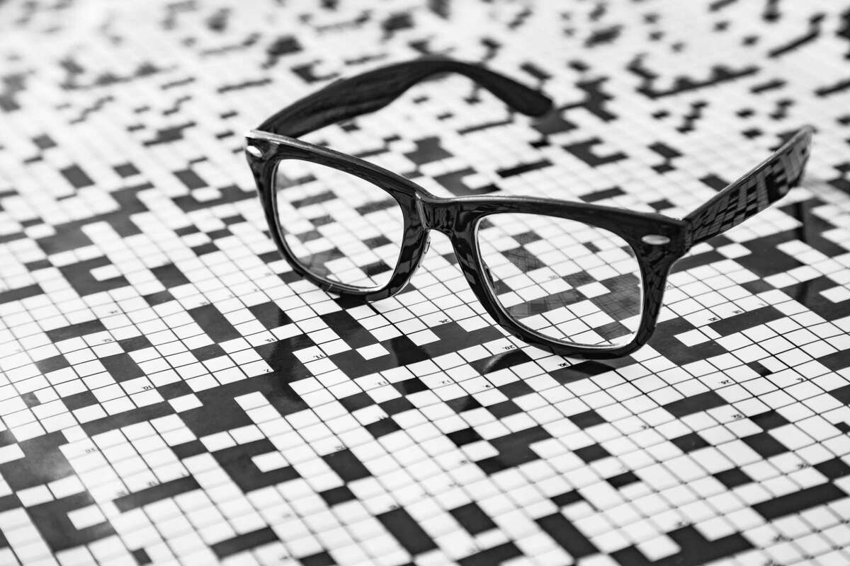 A pair of spectacles with a crossword puzzle background.
