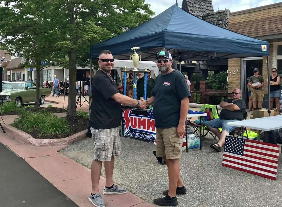 The 3rd Annual Crossroads Car Show sponsored by Betten Baker of Big Rapids this weekend in Reed City brought in over $8,000 for the Veterans' Memorial Park Fund. Winner of the Sponsors Trophy, Kal Kailing (right) is congratulated by organizer Russ Nehmer (left).