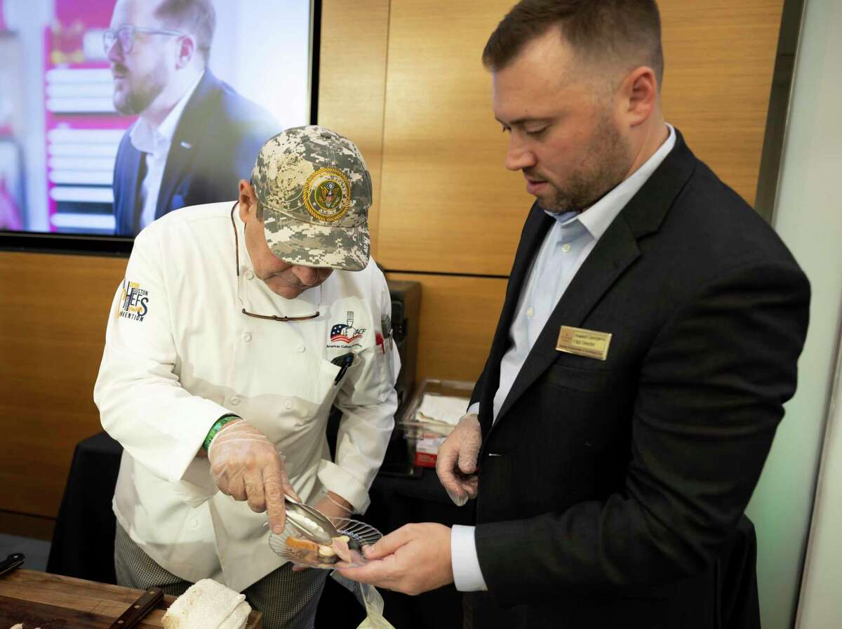 Howard Georgens, right, F&B director of The Woodlands Country Club and Chef Jimmy prepares food during the 17th annual Woodlands Wine and Food Week's Platinum Wine Vault at Bayway Cadillac, Friday, Aug. 20, 2021, in The Woodlands. Over 100 different wines were allocated for the event varying in collectors wines from all around the world. This year’s event is set for Aug. 12 also at Bayway Cadillac.