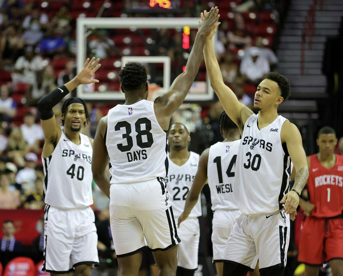 Darius Days #38 of the San Antonio Spurs is congratulated by teammates Javin DeLaurier #40 and Jordan Hall #30 after Days hit a 3-pointer against the Houston Rockets during the 2022 NBA Summer League at the Thomas & Mack Center on July 11, 2022 in Las Vegas, Nevada.