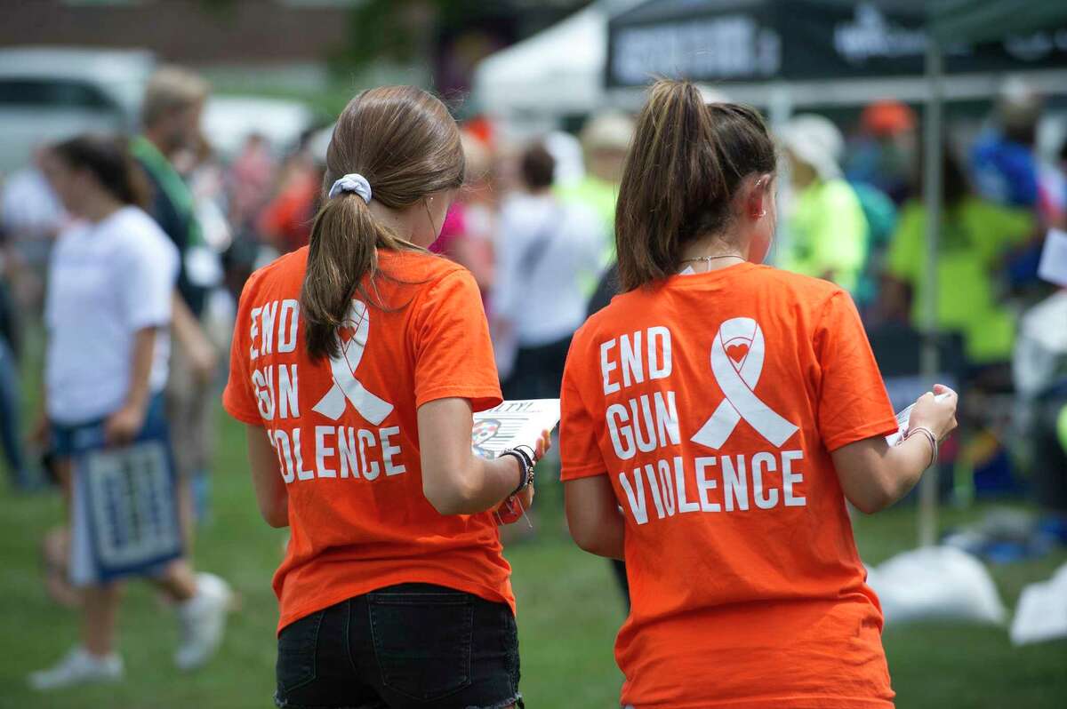 Volunteers wearing "End Gun Violence" shirts hand out informational leaflets during the Road to Change Tour, at the Fairfield Hills Campus in Newtown, Conn. on Sunday, Aug. 12, 2018.