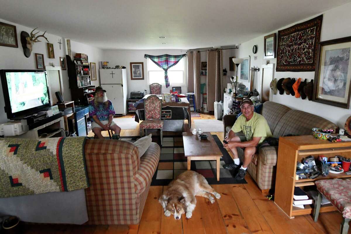 Jim Fulmer of the Peaceatorium, right, sits in the community habitat’s game room on Monday, July 18, 2022, in Ballston Spa, N.Y. The co-housing group has existed for 14 years.