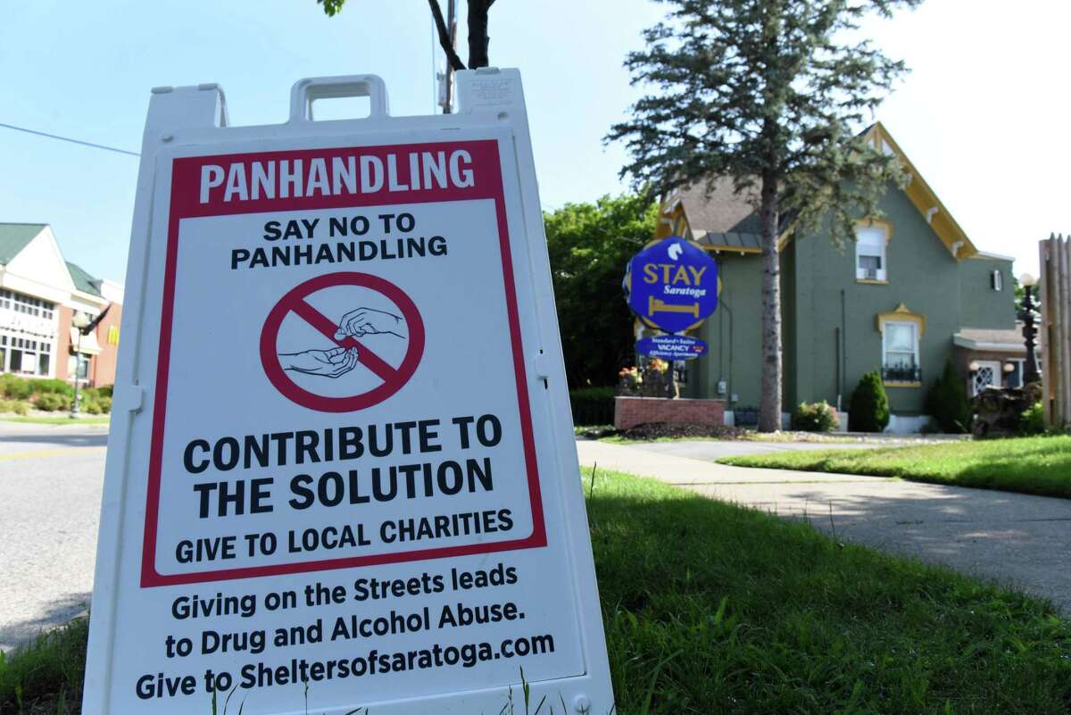 Signs discouraging people from giving money to panhandlers are placed outside Stay Saratoga hotel along South Broadway on Tuesday, July 19, 2022, in Saratoga Springs, N.Y. The hotel owner is fed up with panhandlers who loiter across the street at a nearby Stewart’s Shop.