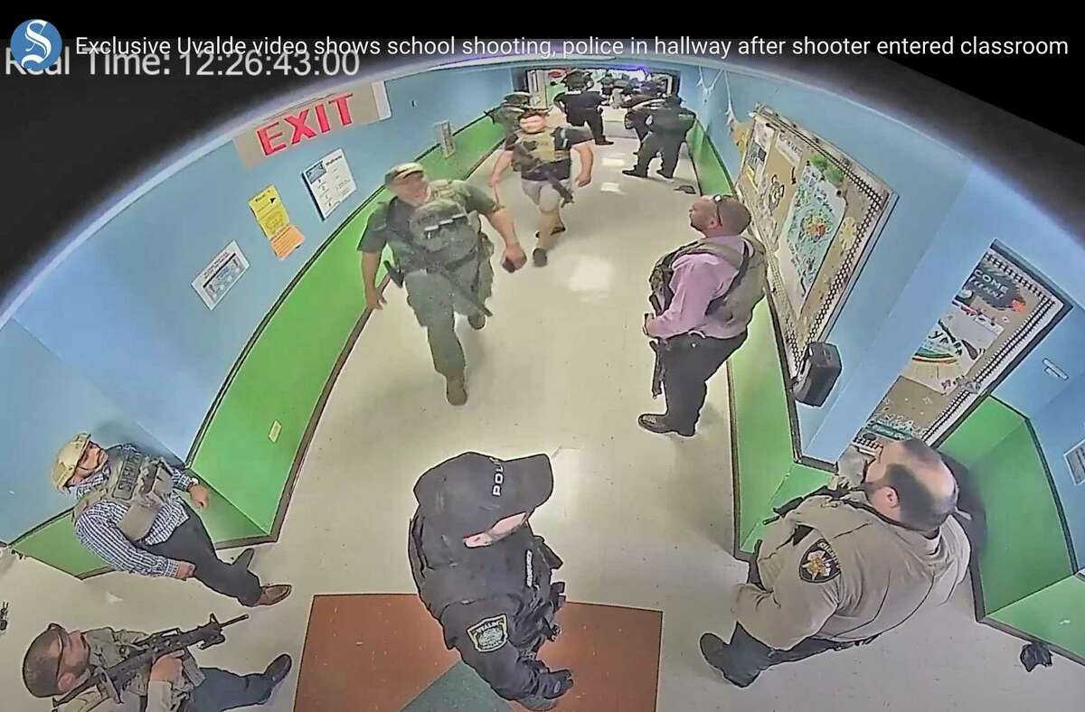 In this photo from surveillance video provided by the Uvalde Consolidated Independent School District via the Austin American-Statesman, authorities stage in a hallway as they respond to the shooting at Robb Elementary School in Uvalde, Texas, Tuesday, May 24, 2022. (Uvalde Consolidated Independent School District/Austin American-Statesman via AP)