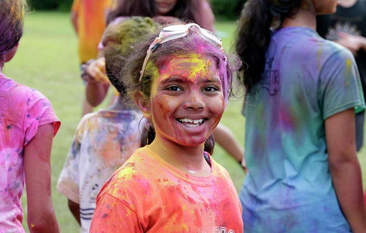 Elementary and middle school aged campers are covered with colored powder during the Holi Festival celebration at the Hindu Heritage Youth Camp Saturday, Aug. 3, 2019 at Camp Lantern Creek near Montgomery, TX.