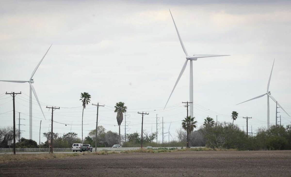 Wind turbines operate as traffic drives on State Highway 77 on Friday, Feb. 11, 2022, near Sebastian.