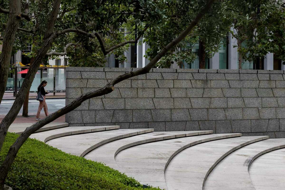 A pedestrian walks past a staircase leading to a sunken public plaza surrounding One Bush Street at the corner of Market and Sutter streets in San Francisco.