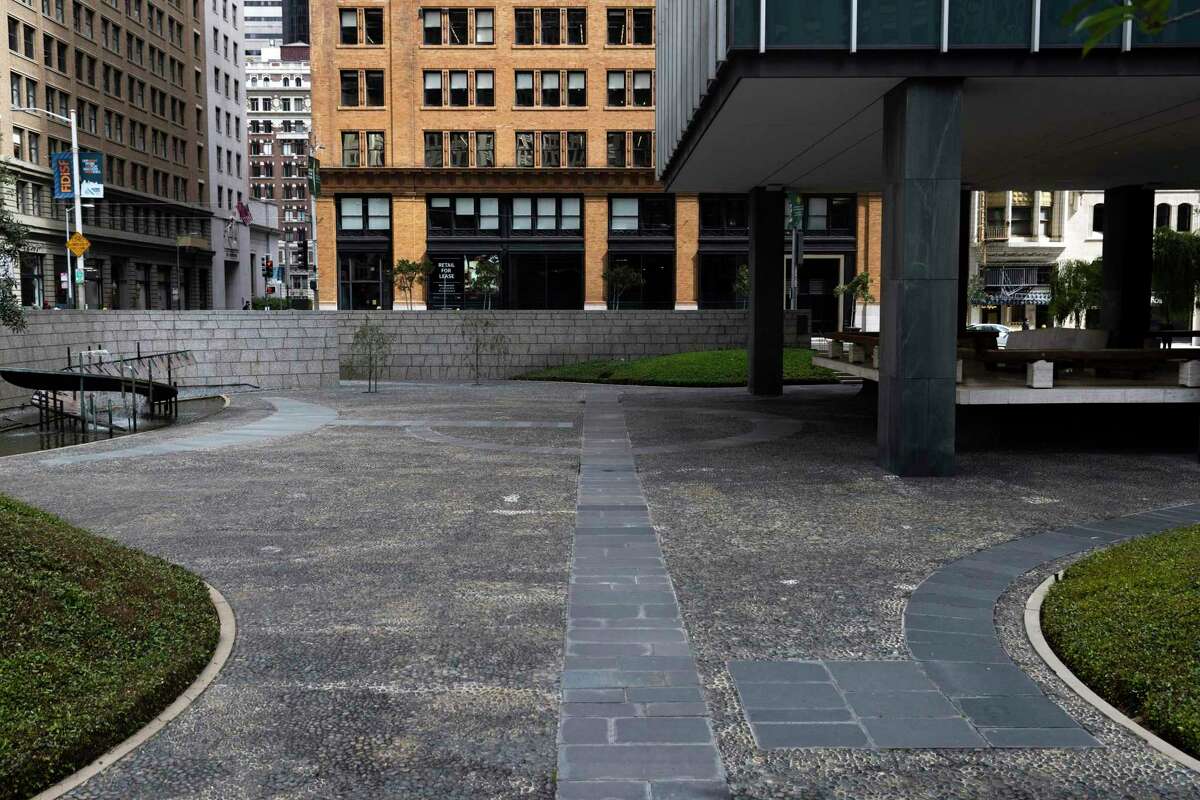 An empty walkway leads through a sunken public plaza surrounding One Bush Street at the corner of Market and Sutter streets in San Francisco.