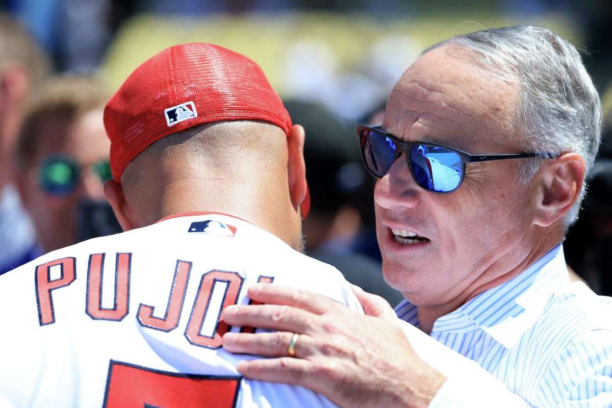 Baseball Commissioner Rob Manfred speaks with Cardinals first baseman Albert Pujols, who’s retiring after the season, during a workout at Dodger Stadium on Monday, before the Home Run Derby.