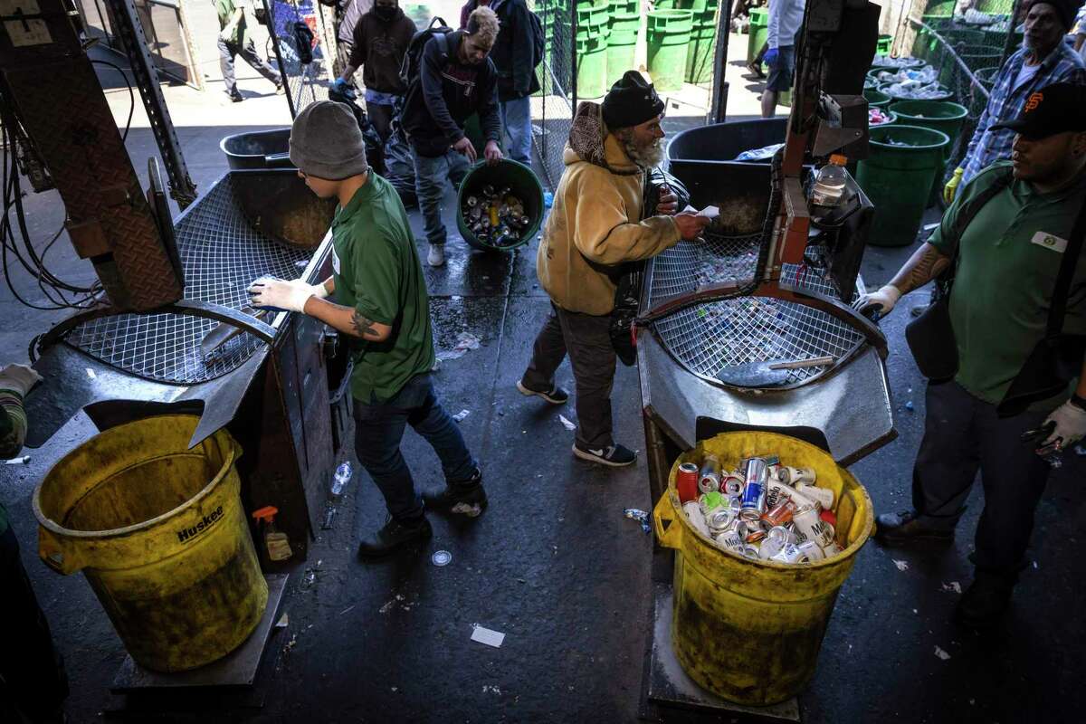 Workers drop sorted recyclables from customers into cans at Our Planet Recycling center in San Francisco. Less than a third of wine and booze bottles are recycled in the state, causing hundreds of millions of them to wind up in landfills every year.
