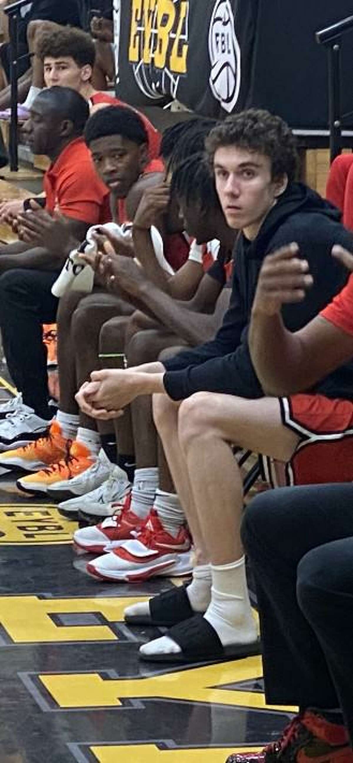 Simsbury's Gavin Griffiths (right) watches from the bench during Expression Elite's Peach Jam game on Tuesday. Griffiths, who has committed to Rutgers, sprained his ankle on Monday but hopes to return to the floor on Wednesday.