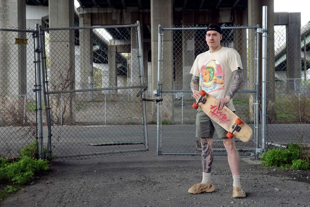 Jim Mazzadra poses in front of the vacant property under the Rt. 8 Commadore Hull Bridge, in Shelton on April 27. Mazzadra is leading efforts to rebuild the skate park that used to stand on the property.