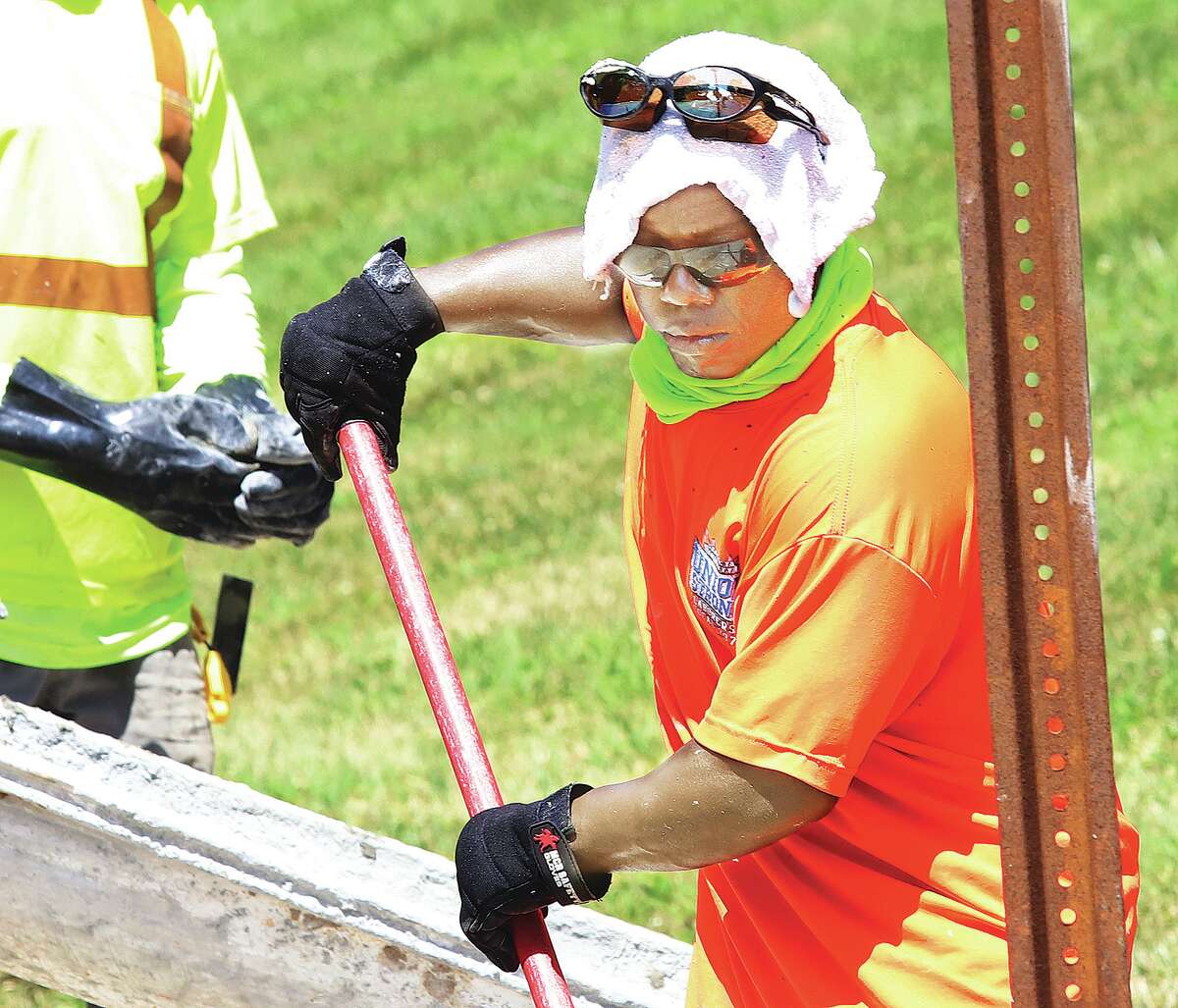 John Badman|The Telegraph A worker from a labor local uses a wet rag on his head to stay cool Wednesday while helping to pour a sidewalk in front of Alton Middle School. Summer heat and humidity were making outdoor chores unpleasant.