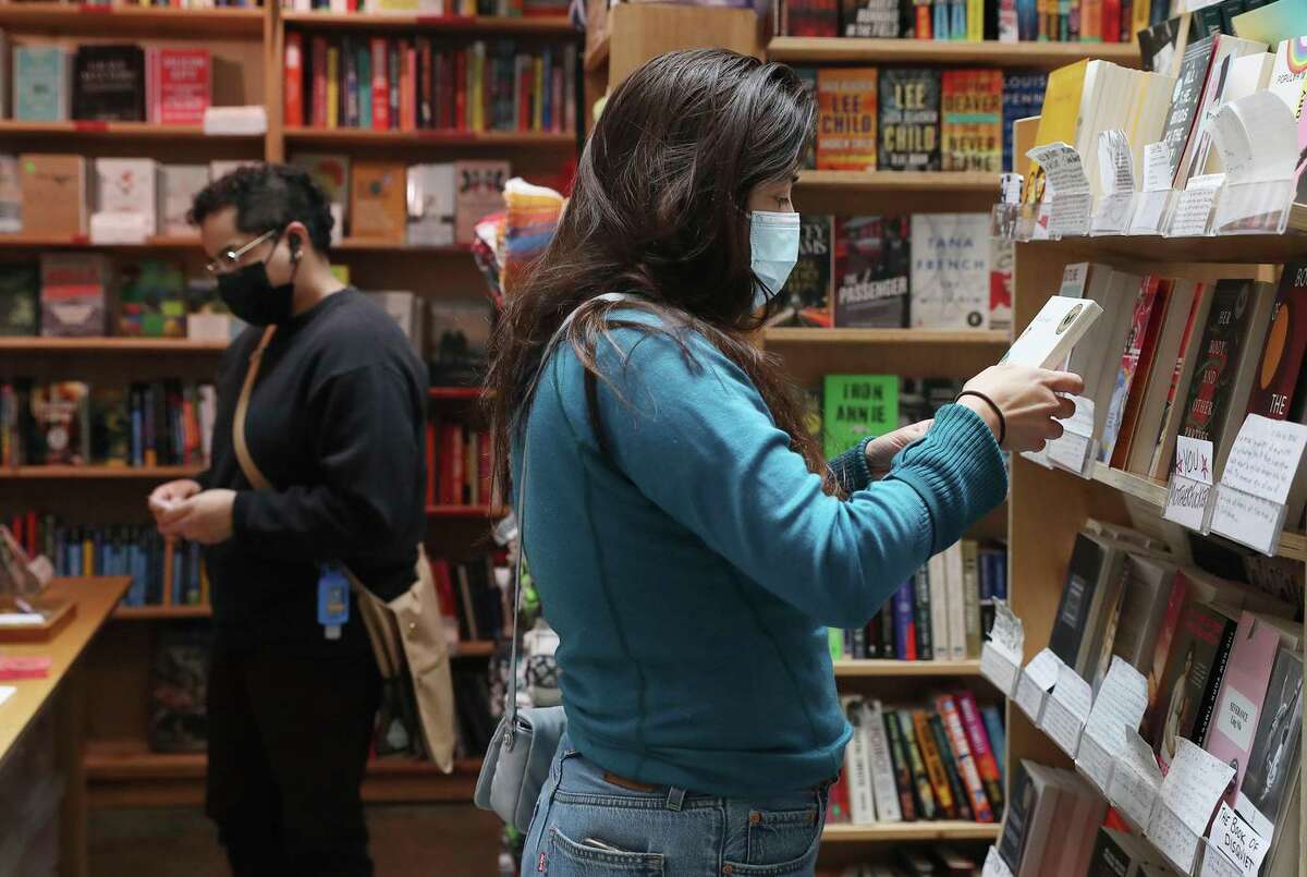 希尔达·拉莫斯在旧金山第九大道公园的绿苹果书店里看书。这家店的经营状况比去年好，销售税收也相应增加。