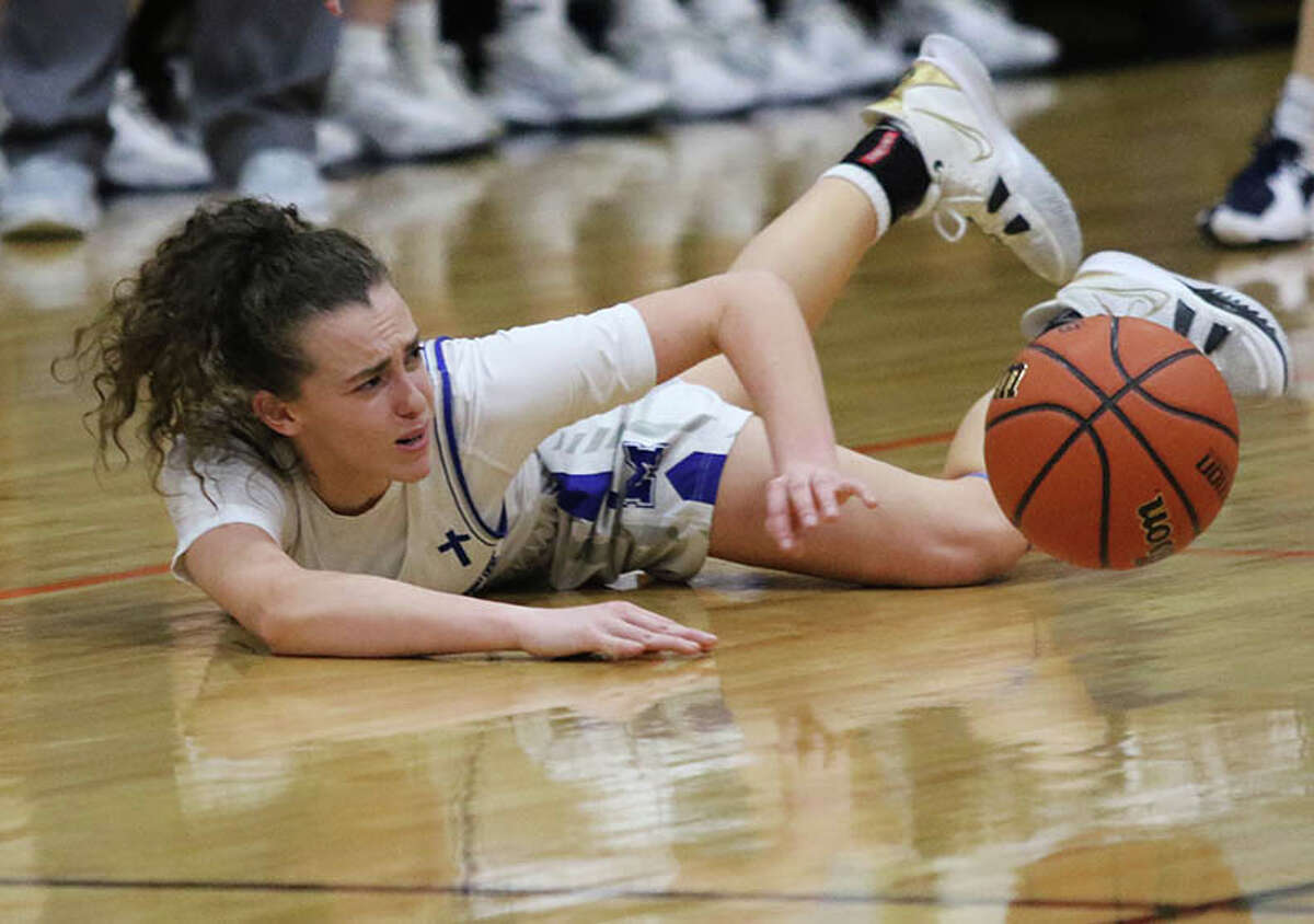 Marquette's Chloe White passes to a teammate after going to the floor to make a steal against Carthage Illini West during a semifinal at last season's Waverly Class 2A Sectional.