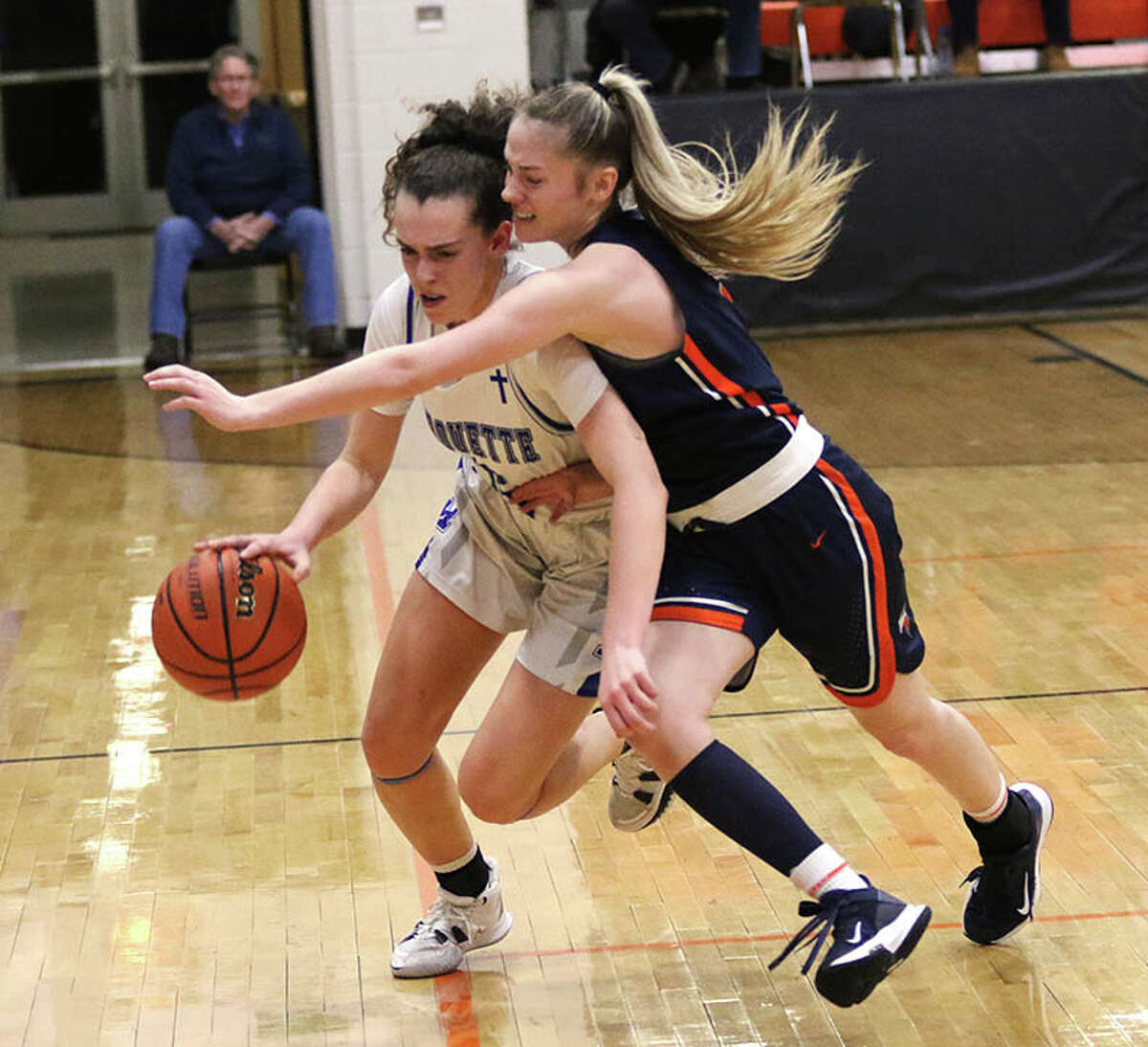 Marquette's Chloe White (left) pushes the ball upcourt against tight defense from Carthage Illini West's Caydee Kirkham during a semifinal at last season's Waverly Class 2A Sectional. White is the 2022 Telegraph Small-Schools Girls Basketball Player of the Year.