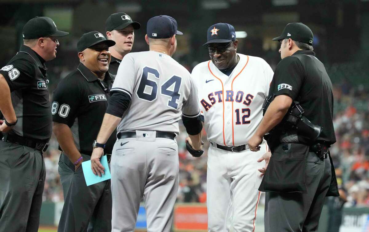 Houston Astros manager Dusty Baker Jr. (12) greets New York Yankees bench coach Carlos Mendoza (64) for the lineup exchange before the start of the first inning of game one of a double header MLB baseball game at Minute Maid Park on Thursday, July 21, 2022 in Houston.