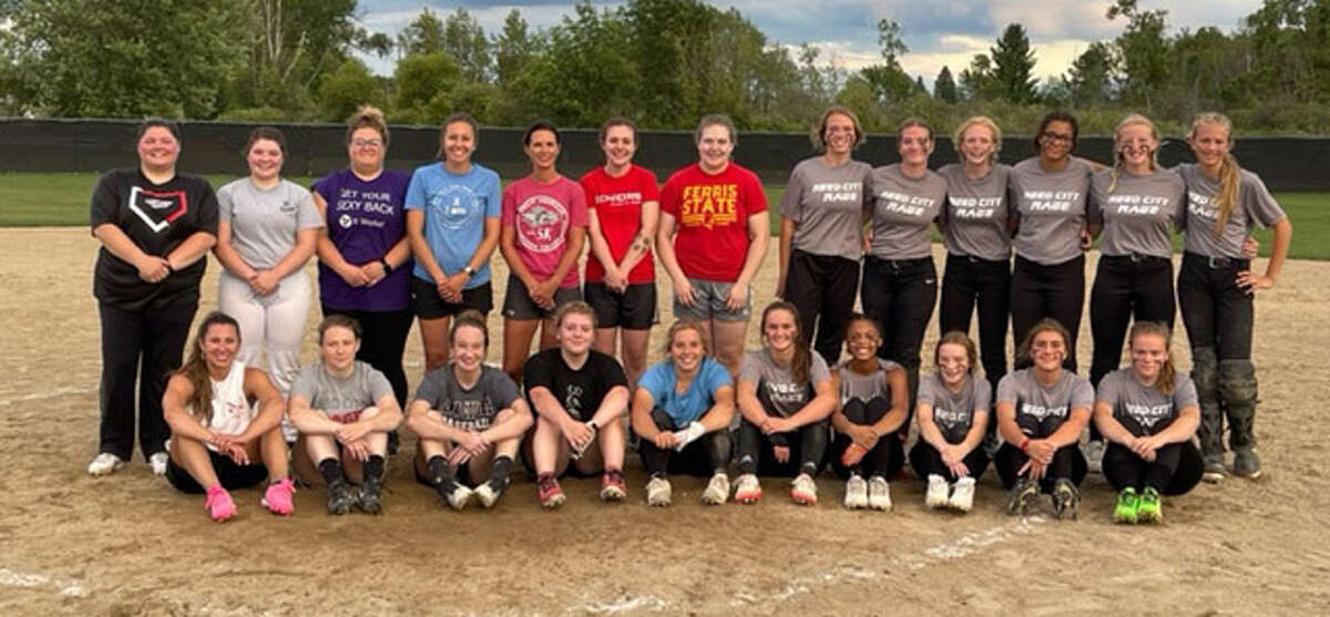 Reed City former and current softball players posed for a team picture after Wednesday's game