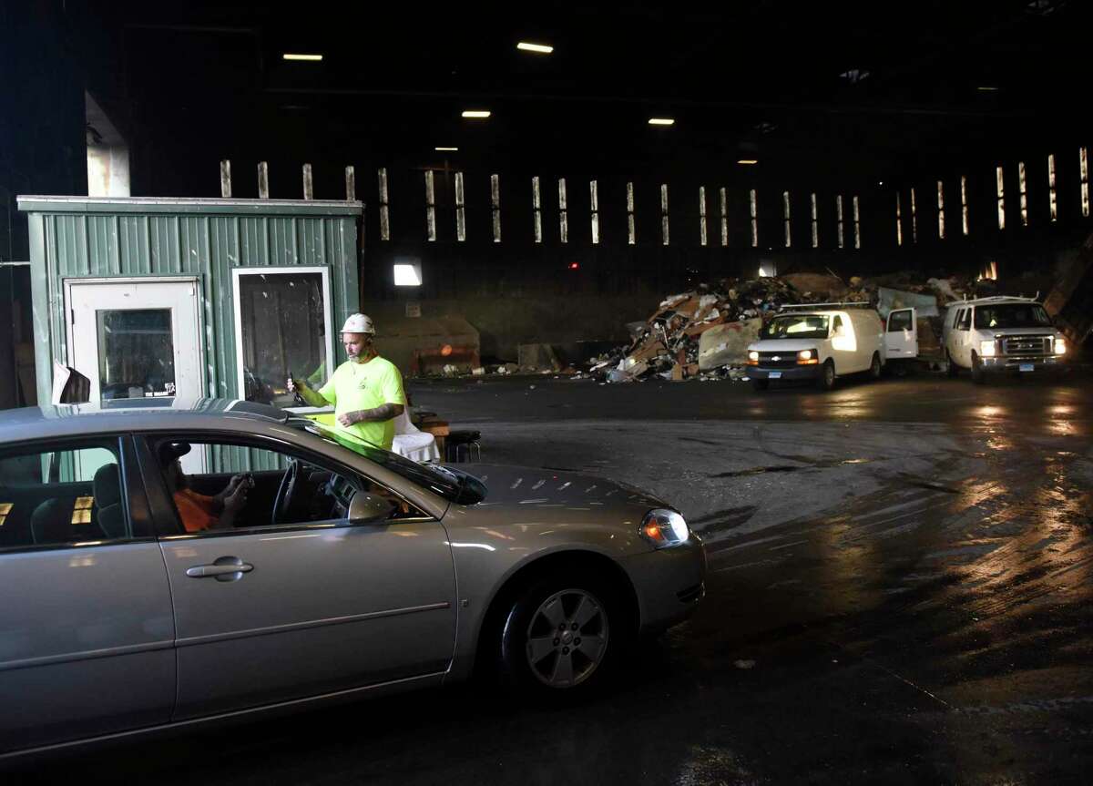 Heavy equipment operator Pete Scrofani checks in vehicles lined up to throw out trash during the early morning rush at the Transfer Station in Stamford, Conn. Tuesday, July 19 2022. The Board of Representatives is brainstorming solutions to ease the immense capacity at the Stamford Transfer Station.