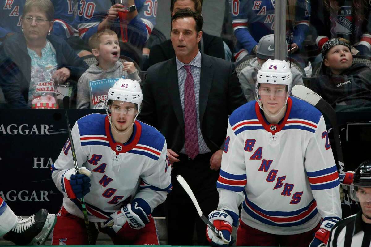 New York Rangers head coach David Quinn watches his team play against the Dallas Stars with center Brett Howden (21) and right wing Kaapo Kakko (24) during the third period of an NHL hockey game in Dallas, in this Tuesday, March 10, 2020, file photo.