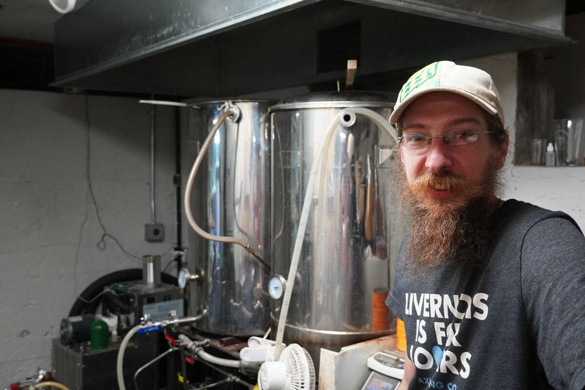 Nick Bowlby, brewer at Thumb Brewery stands by his current setup in the basement of Thumb Brewery.