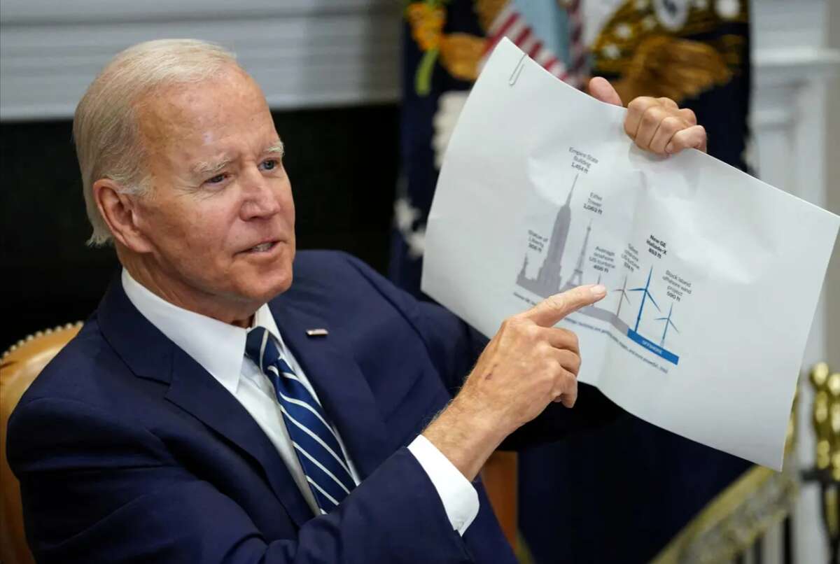 U.S. President Joe Biden holds up a wind turbine size comparison chart while attending a meeting with governors, labor leaders and private companies launching the Federal-State Offshore Wind Implementation Partnership at the White House on June 23.