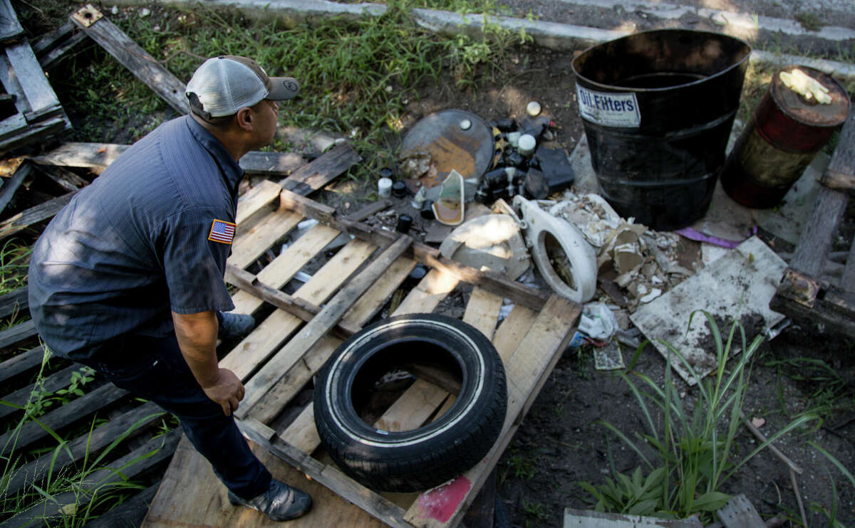 Joe Gonzalez, a deputy constable with Harris County Constable's Office Precinct One, investigates an illegal dump site in a north Houston neighborhood on Aug. 1, 2018.