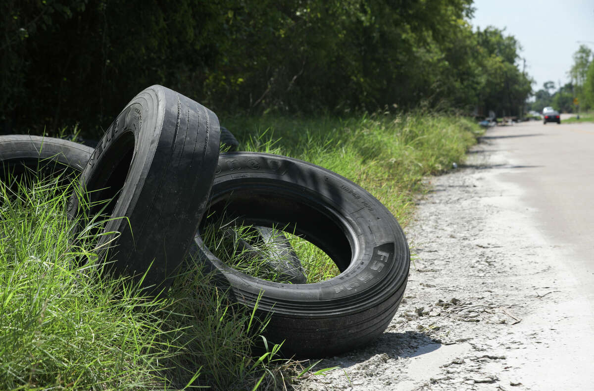 Illegally-dumped tires and other trash sits on Maxine Street on Sept. 8, 2021, in Houston.