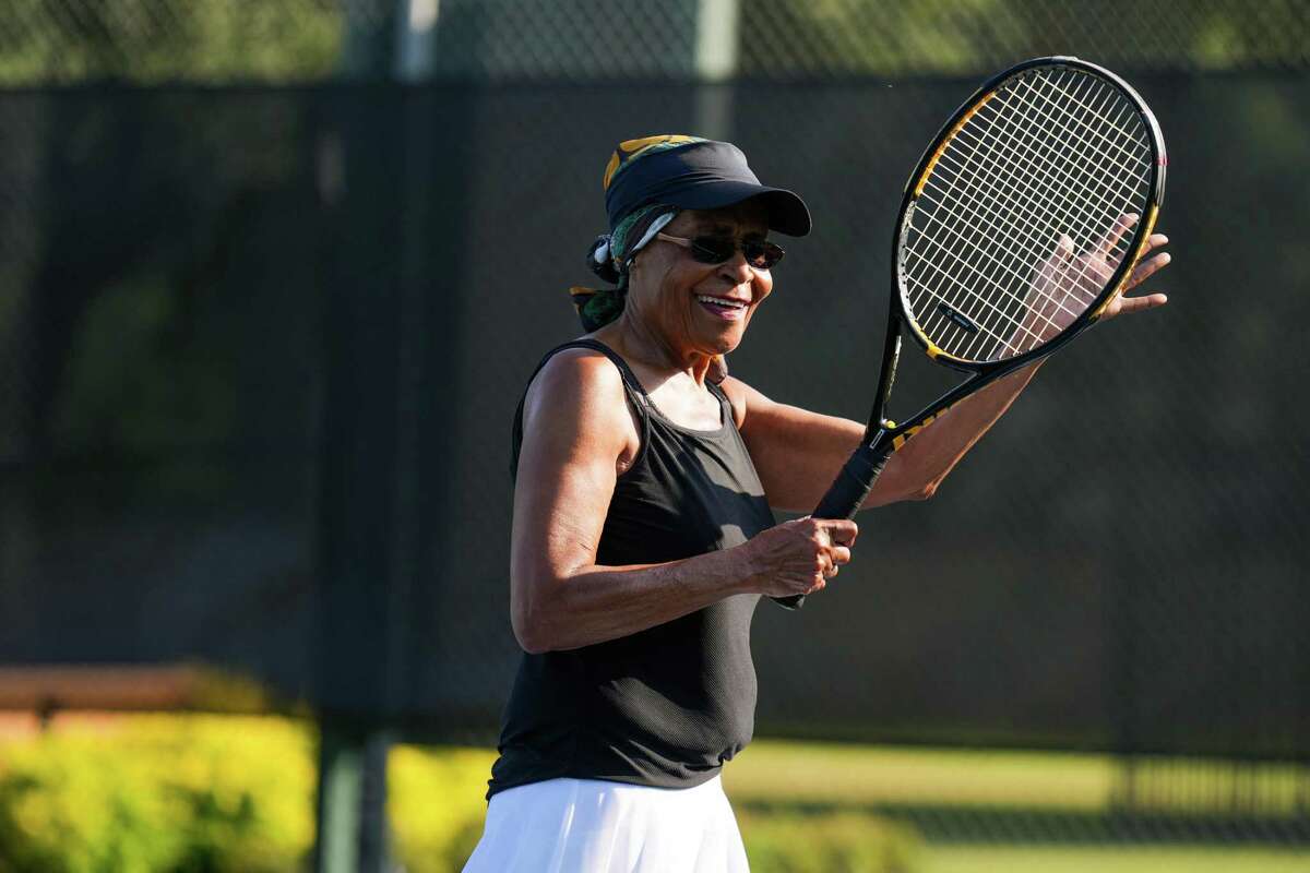 2022 年 6 月 20 日星期一，在休斯敦，维诺拉·乔利 (Venola Jolley) 在坎宁安溪娱乐中心的网球场上与朋友们一起打网球，她为一次击球喝彩。