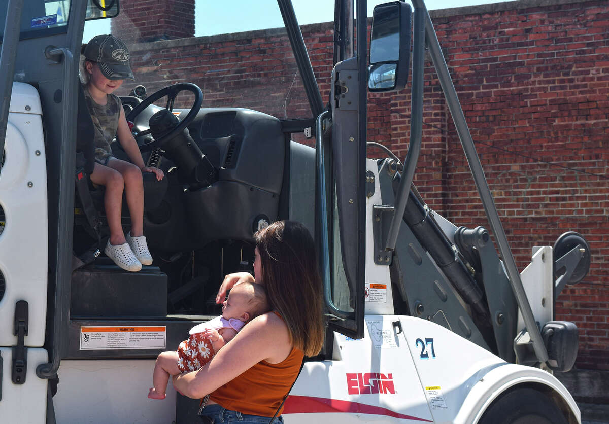 Jett Little, 2, sits behind the wheel of a street sweeper Friday in a touch-a-truck display at Jacksonville Public Library. The hands-on event celebrated the end of the library's summer reading program. Children also could peek inside a fire truck and an ambulance. Jett was there with his mother, Jewel McEvers, who was looking on.