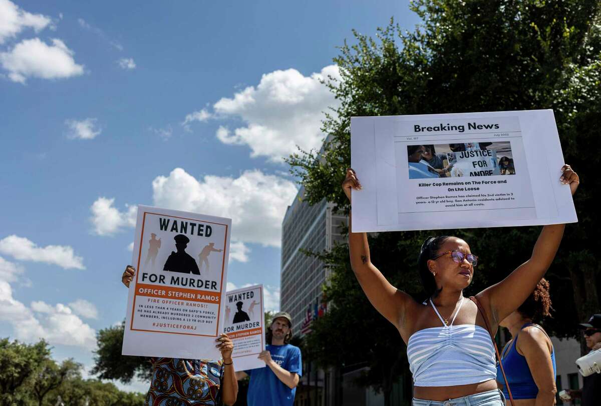 Kimiya Factory, founder and executive director of Black Freedom Factory, holds up a sign in view of oncoming traffic during a rally held for 13-year-old Andre "AJ" Hernandez outside San Antonio police headquarters on July 2022.